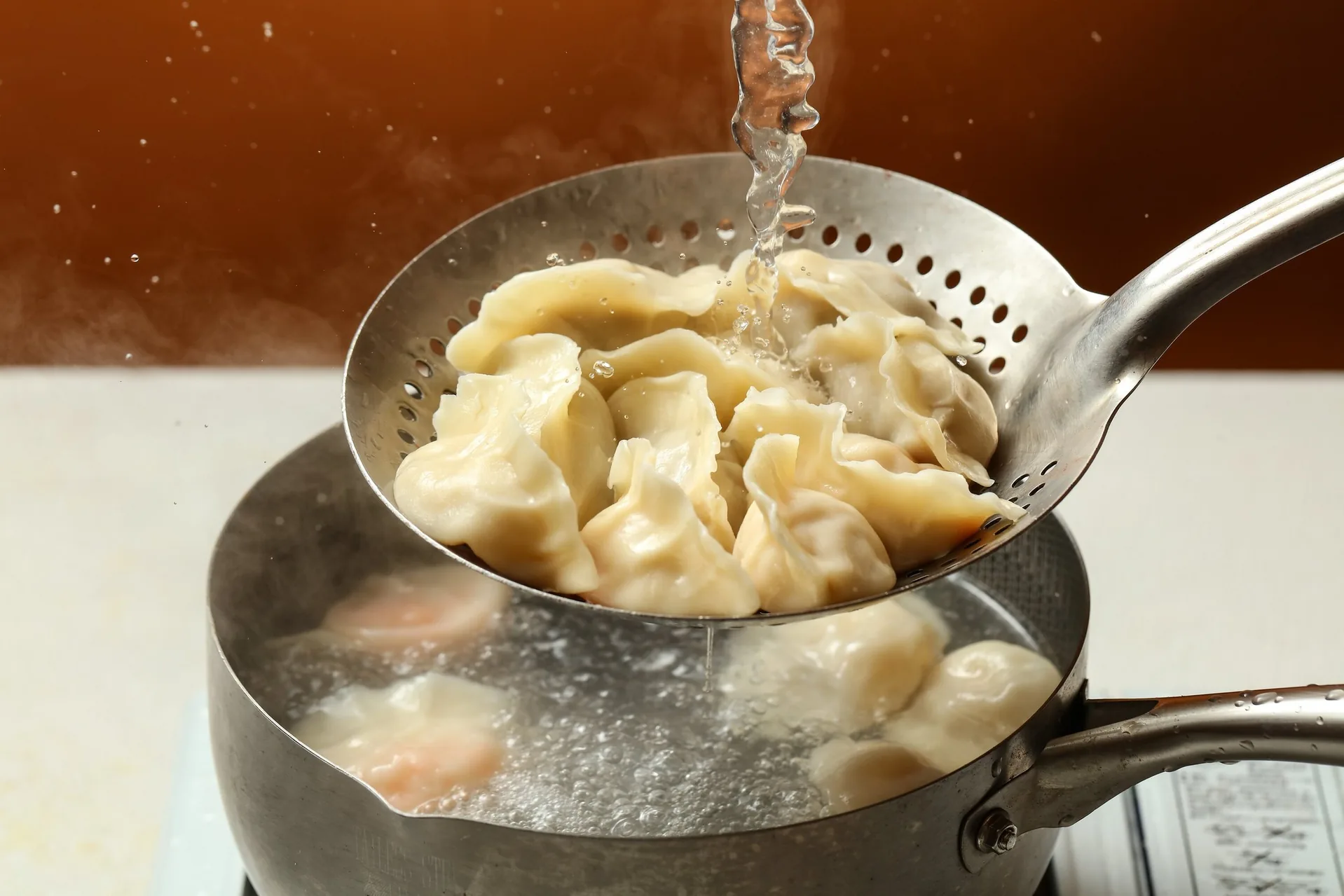 Dumplings lifted from boiling water with a strainer